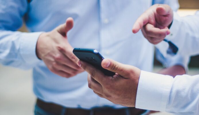 Men pointing at a smartphone